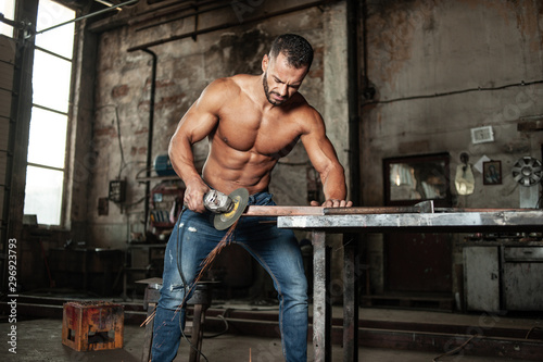 Obraz na płótnie Muscled half naked man at work in an old factory. w salonie