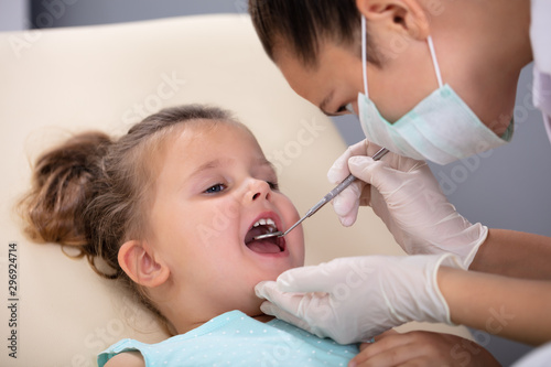 Girl Having His Teeth Examined By A Dentist