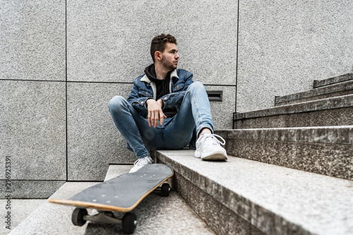 Young man sitting with saketeboard on stairs