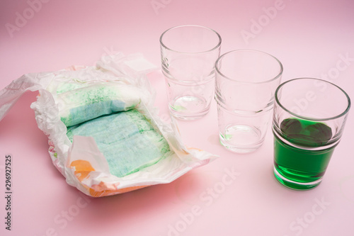 Baby diapers with liquid absorbance on pink background
