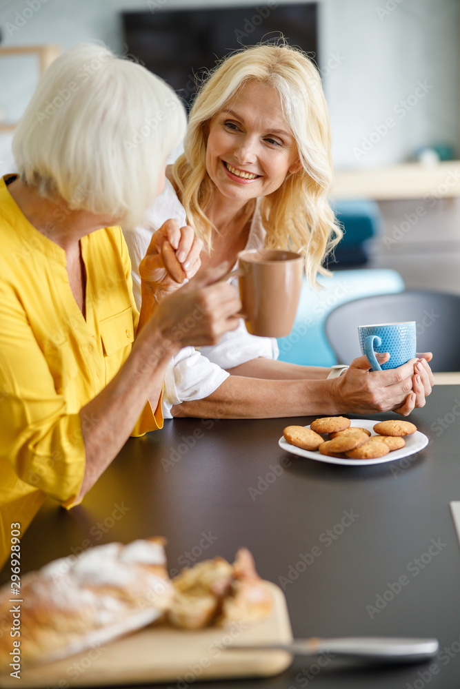 Adult mother sitting with daughter in the kitchen