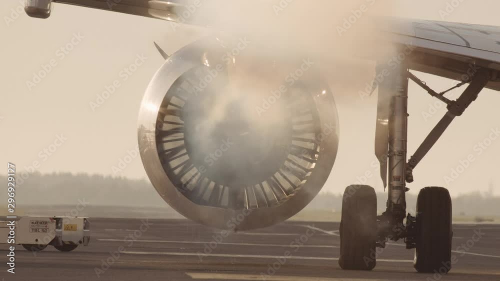 Looking at the back of a jet turbine during cold start-up with smoke on an early morning flight
