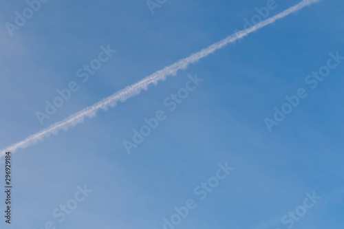 Blue sky with Condensation Trails by jet engine. © Cheewamet