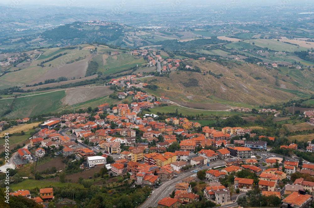 Aerial view of countryside village with red rooftops and vast farmlands