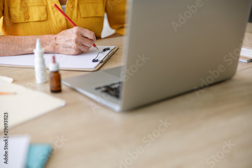 Adult woman holding pencil at the table