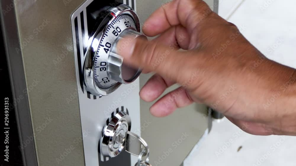 The man's hand is opening the safe door lock