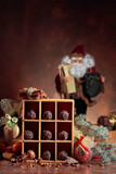 Chocolate candy in wooden box and Christmas decorations on a old brown table.