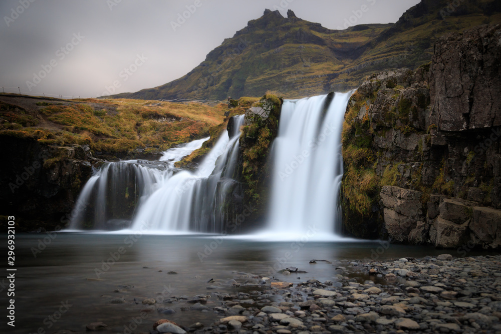 Kirkjufell mountain, Iceland. Beautiful sunset over icelandic landscape with mountain and waterfalls