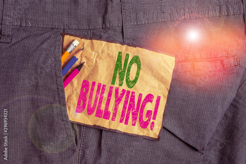 Handwriting text writing No Bullying. Conceptual photo stop aggressive behavior among children power imbalance Writing equipment and brown note paper inside pocket of man work trousers