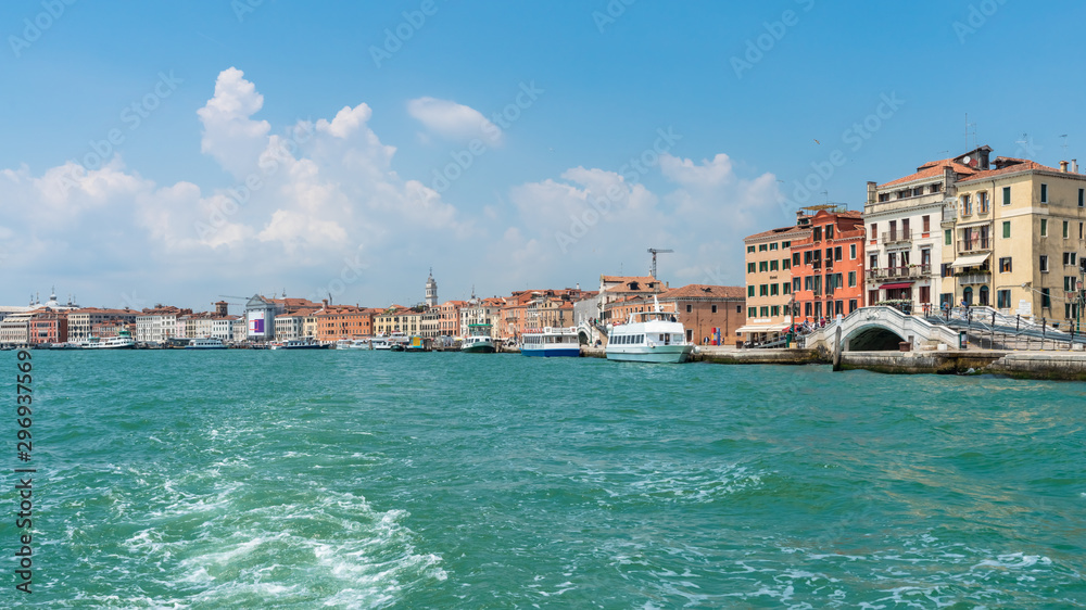 Venice. View of Venice from the Grand Canal. Venetian old colorful buildings against blue sky and white clouds. Boat trip through the canals of Venice.