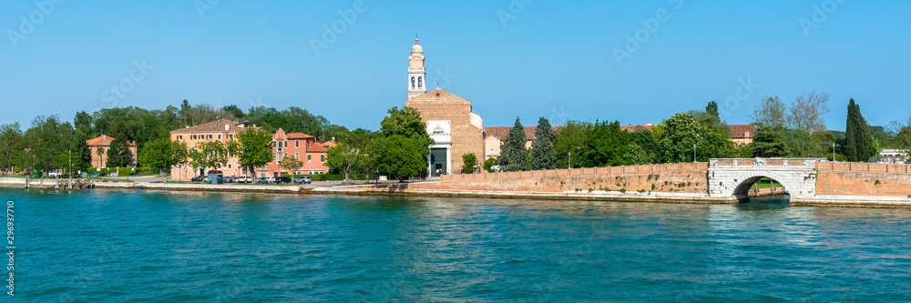Venice. Island Lido. Panoramic view of beautiful embankment of Lido island with Saint Nicolas Church. Blue sky and green trees background. Header. Banner. Venice. Island Lido. Panoramic view of beautiful embankment of Lido island with Saint Nicolas Church. Blue sky and green trees background. Header. Banner.