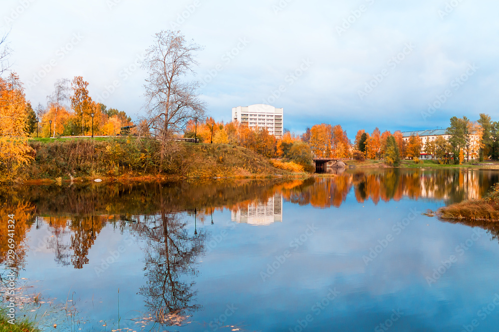 beautiful autumn landscape with yellow-orange trees and reflection in the water