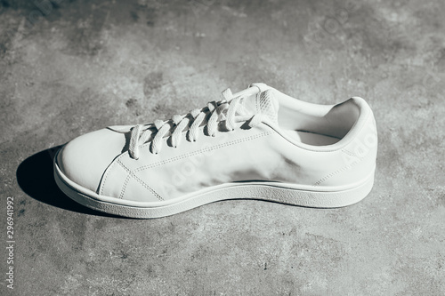 White sneaker on gray background. Stylish white sneaker