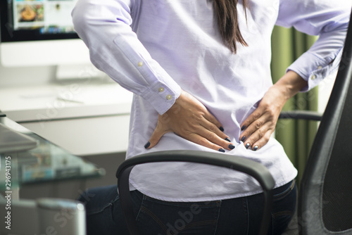 Woman sitting at office having back pain due to bad position or having a not ergonomic chair © adrian_ilie825