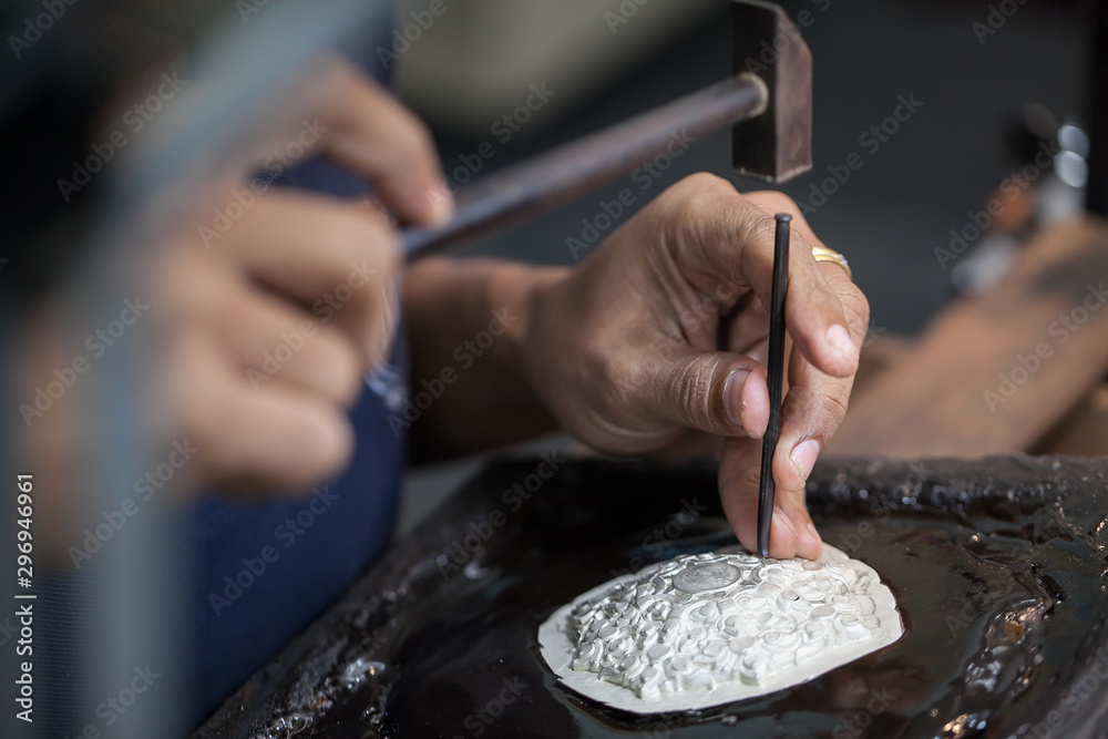 Silversmith using hammers and steel engraved  pattern on silver plate for accessory handmade - obrazy, fototapety, plakaty 