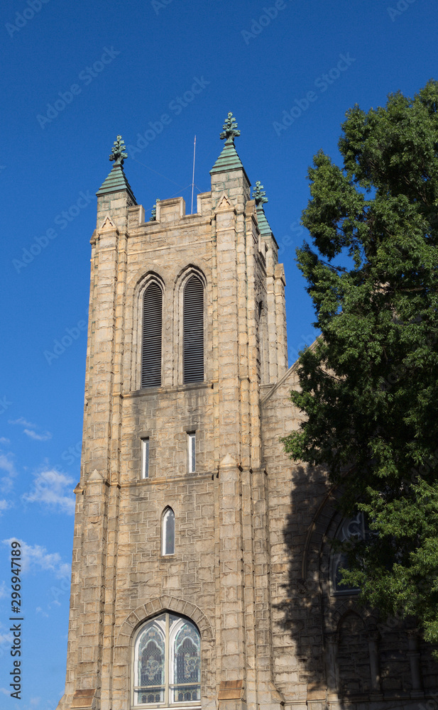 Stone Church Bell Tower by Tree on Clear Blue Sky
