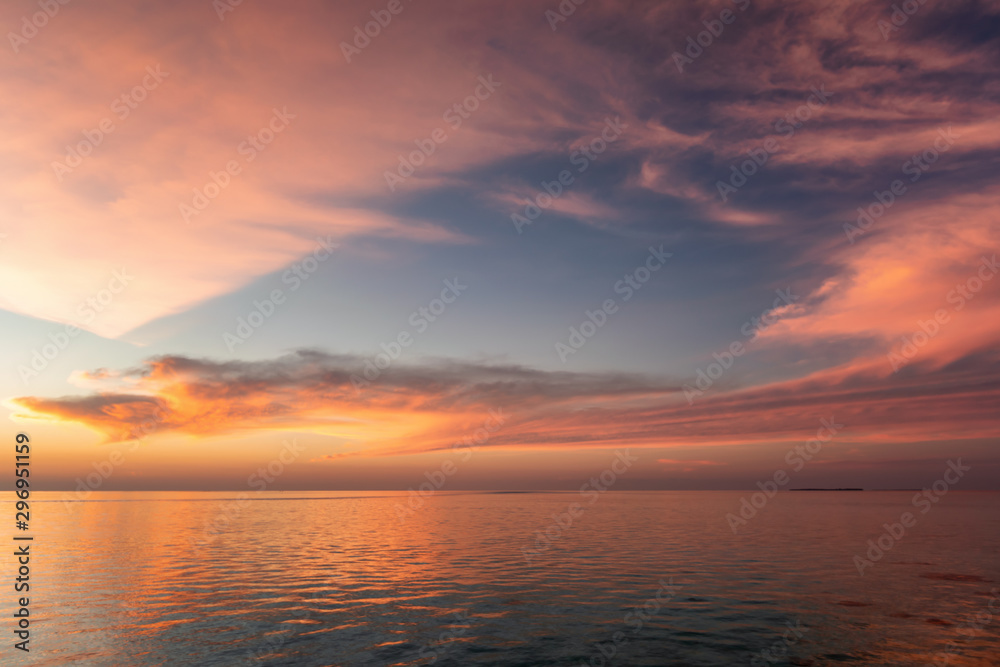 Tropischer Himmel über dem Meer bei Pastellrotem Sonnenuntergang