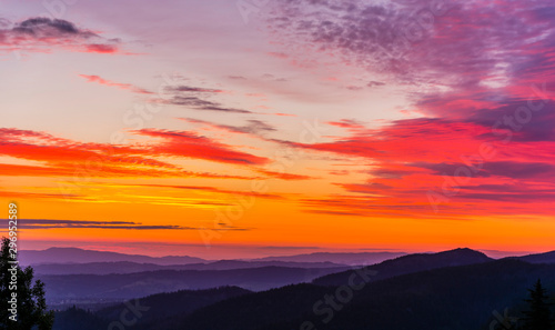 Beautifully the colors (orange, red, purple) of the sky at sunrise over the mountains and valleys.