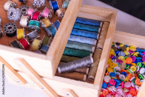 Yarn rolls and thread reels in a wooden sewing box
