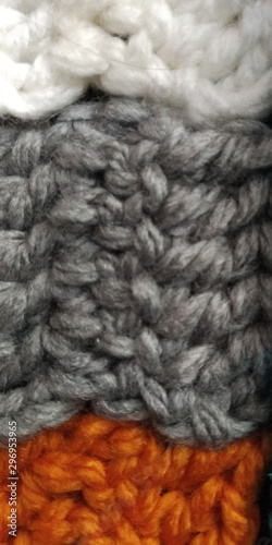 Tejido de lana a rayas de color gris, blanco y naranja.