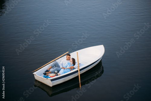 Love couple lying in a boat on lake  top view