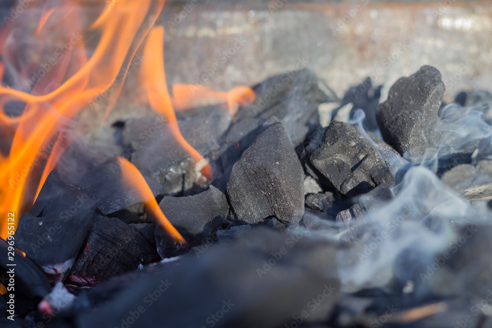 Burning charcoal with smoke and flame. Fire, grill concept. Close-up, copy space