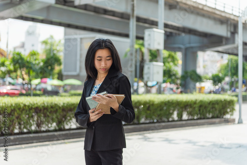 Women are standing reading books, planning work outside the company, the concept of successful business operations of the company. 