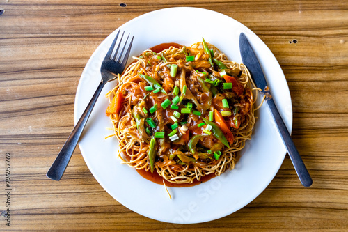 American Chopsuey served in a white plate on wooden surface