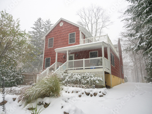 red suburban house under the first snow of the season in November in the East Coast USA