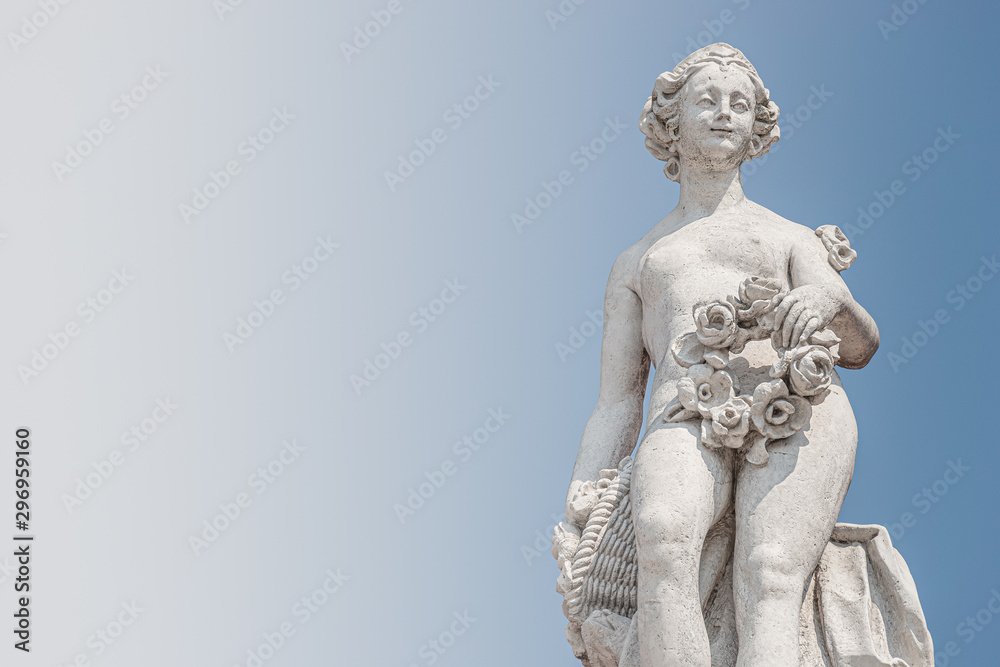 Ancient top roof statue of sensual Italian Renaissance and Rococo Era naked woman in Potsdam at blue sky, Germany