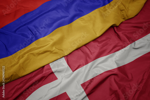 waving colorful flag of denmark and national flag of armenia.