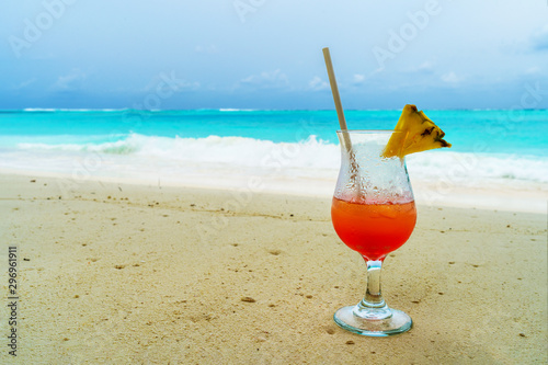Glass of cocktail is on sandy coral beach, Maldives, The Indian