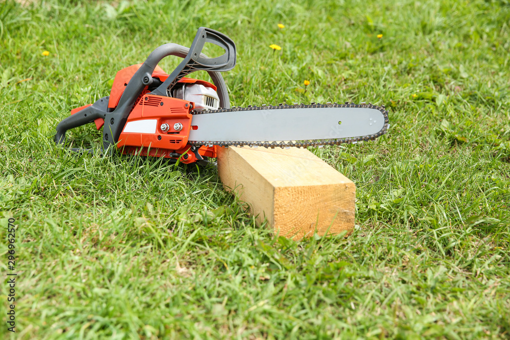 chainsaw on grass close up with copy space. chainsaw on a wooden bar