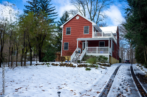 red suburban house after the first snow of the season in November in the East Coast USA