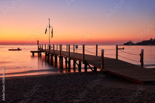 Sea dawn overlooking a large wooden pier and swimming pontoon.