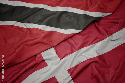 waving colorful flag of denmark and national flag of trinidad and tobago.