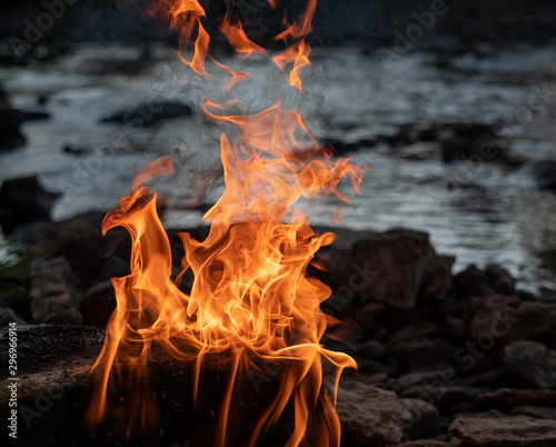 burning fire on a stone in the middle of the river