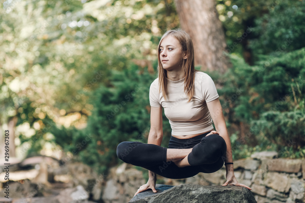 Yoga exercise outdoors. Scales lotus poses. Girl in lotus pose on the stone Yoga exercise outdoors. Scales lotus poses. Girl in lotus pose on the stone