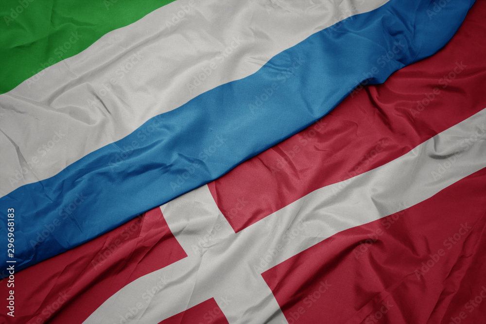 waving colorful flag of denmark and national flag of sierra leone. waving colorful flag of denmark and national flag of sierra leone.