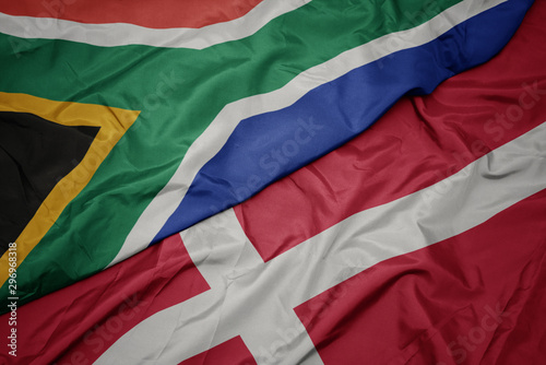 waving colorful flag of denmark and national flag of south africa.