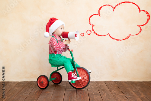 Happy child dressed Santa Claus costume playing at home