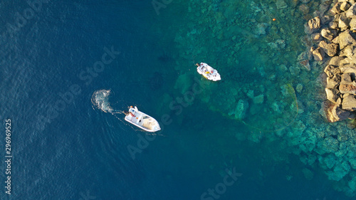 Aerial top down photo of fishing boat in small port of Ammoudi, Santorini island, Cyclades, Greece