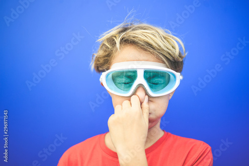 Принти на полотні Beautiful boy with eyes squeezed stuffy nose wearing diving mask, isolated on a blue background