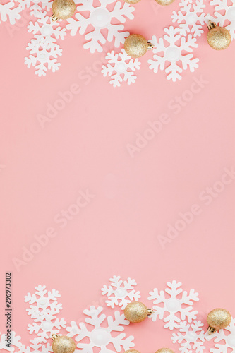 Christmas gift in women's hands and notebook on a pink background, a view from above
