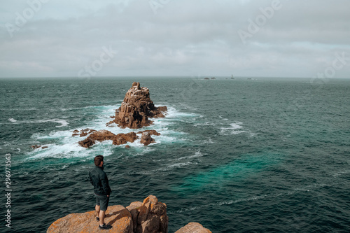 Man on top of cliff admiring the ocean