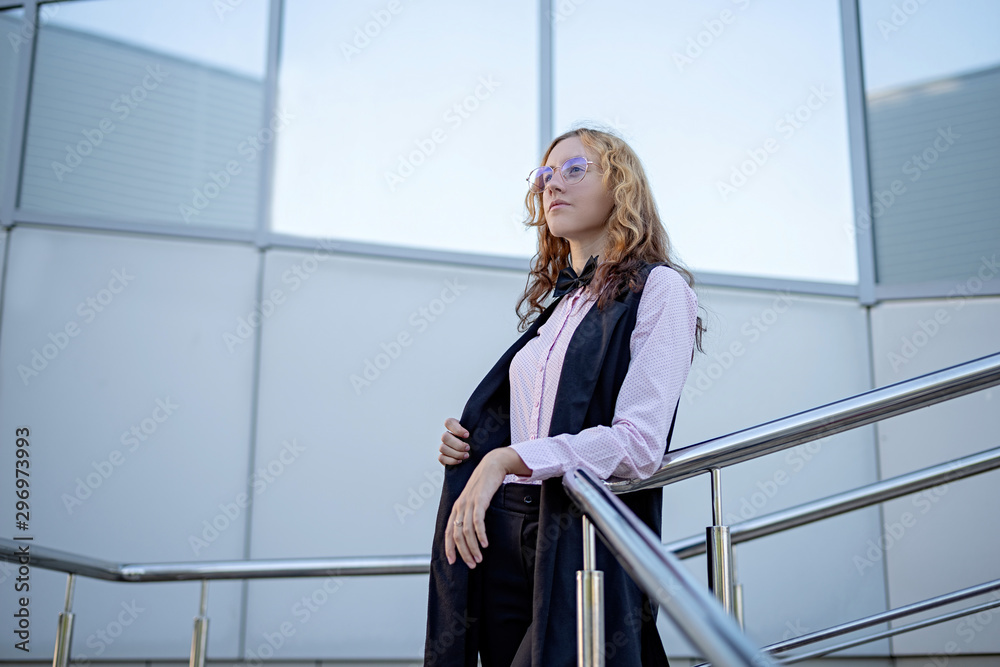outdoor portrait of a confident business woman standing next to the building