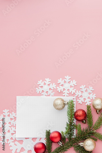 New year concept. Goals list in notepad, gift box and christmas decoration on pink pastel color with copy space