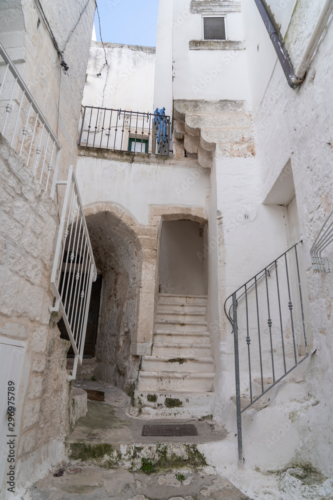 OSTUNI, ITALY - April 30, 2019: touristic trip. Travel view of Ostuni featuring some white houses part of the center of the village, historical center. The image location is Apulia in Italy, Europe.