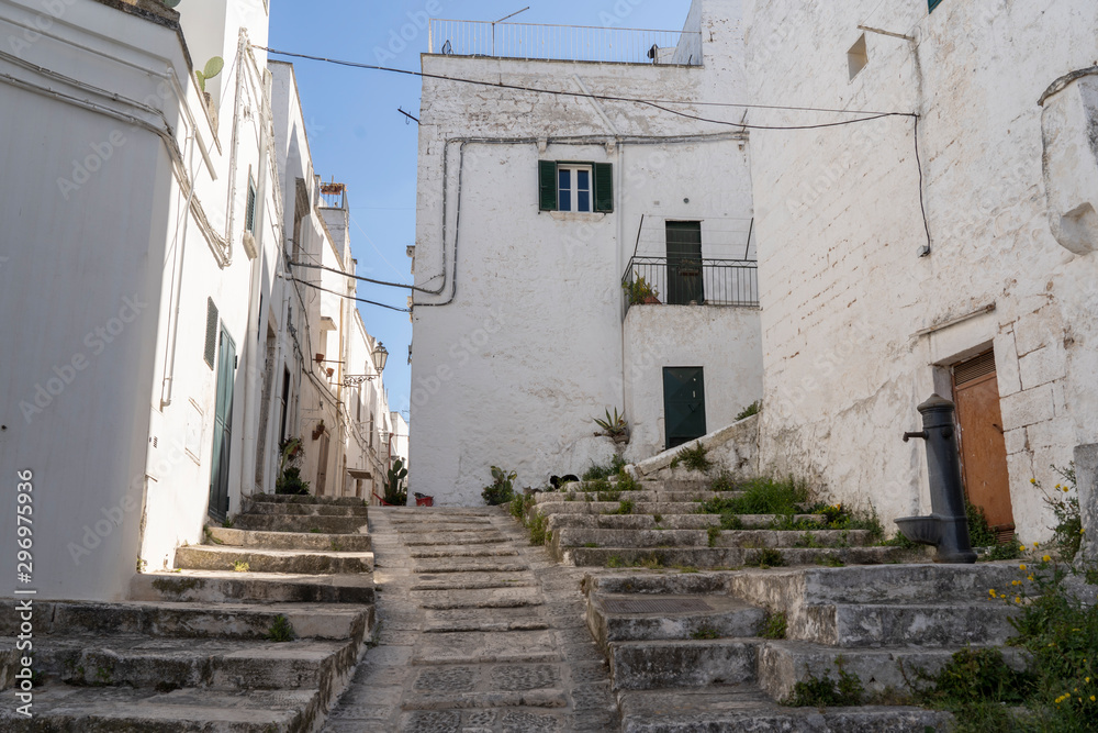 OSTUNI, ITALY - April 30, 2019: touristic trip. Travel view of Ostuni featuring some white houses part of the center of the village, historical center. The image location is Apulia in Italy, Europe.