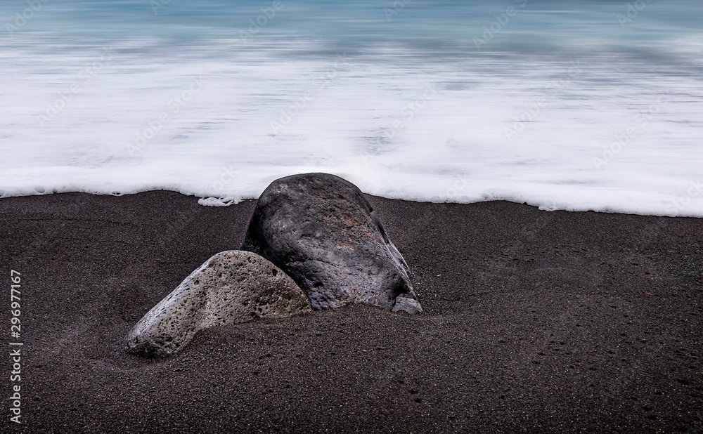 Obraz premium Big couple of rocks on the sand at the beach
